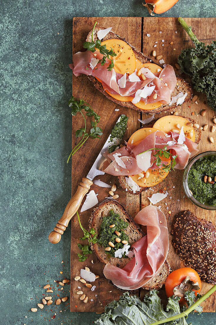 Persimmon crostini with prosciutto, kale pesto and parmesan