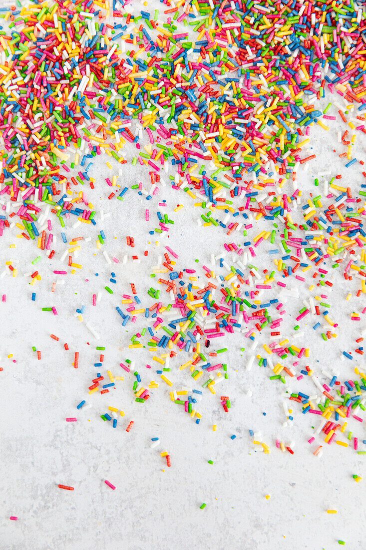 Colourful sugar sprinkles on a white surface