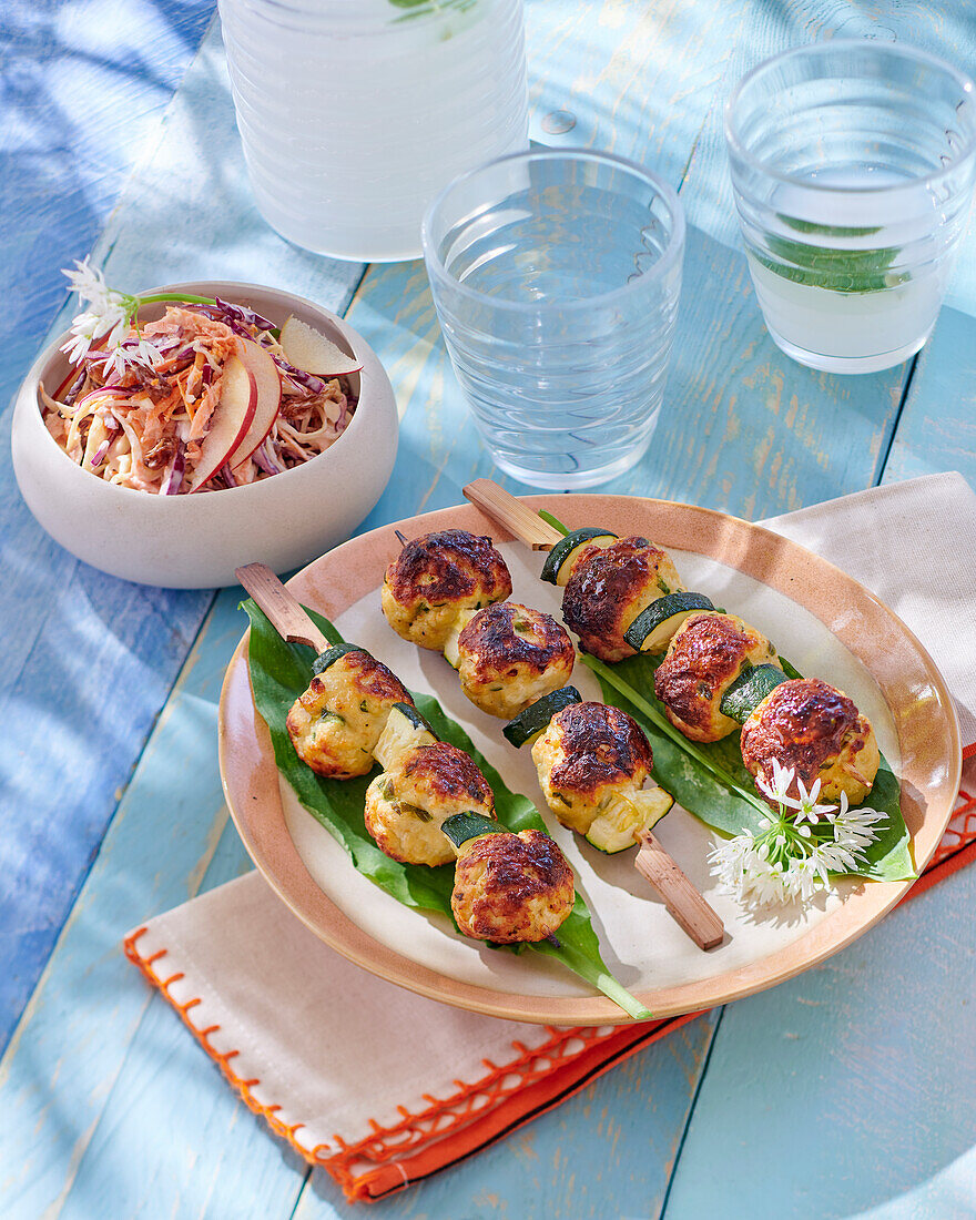 Grilled chicken meatballs on skewers with coleslaw