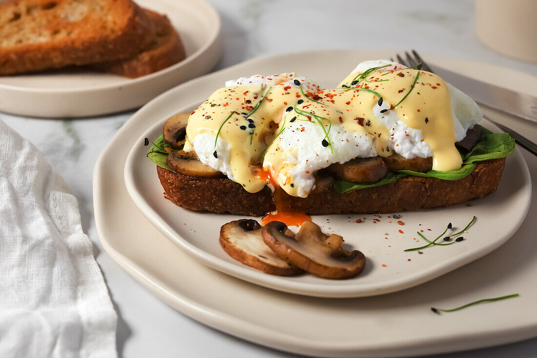 Toasted sourdough bread with spinach, mushrooms, poached eggs and hollandaise sauce