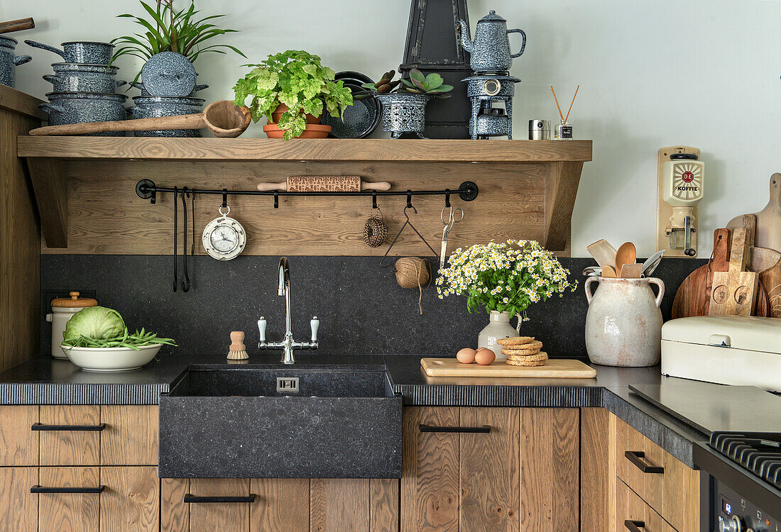 Country kitchen with dark sink and wooden cupboards