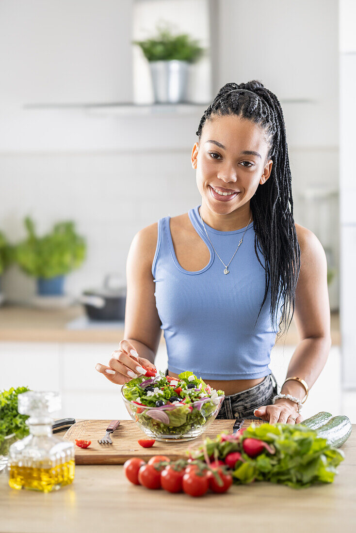 Women's hands mix a healthy spring salad from various ingredients