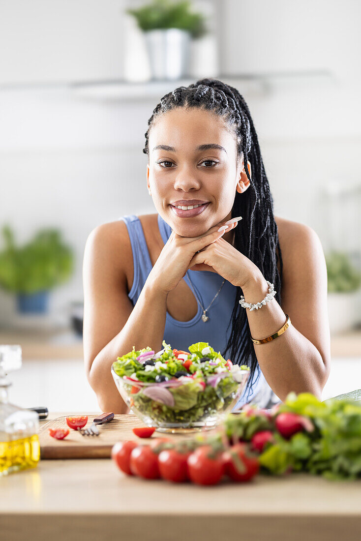 Young African-American woman prepares healthy salad