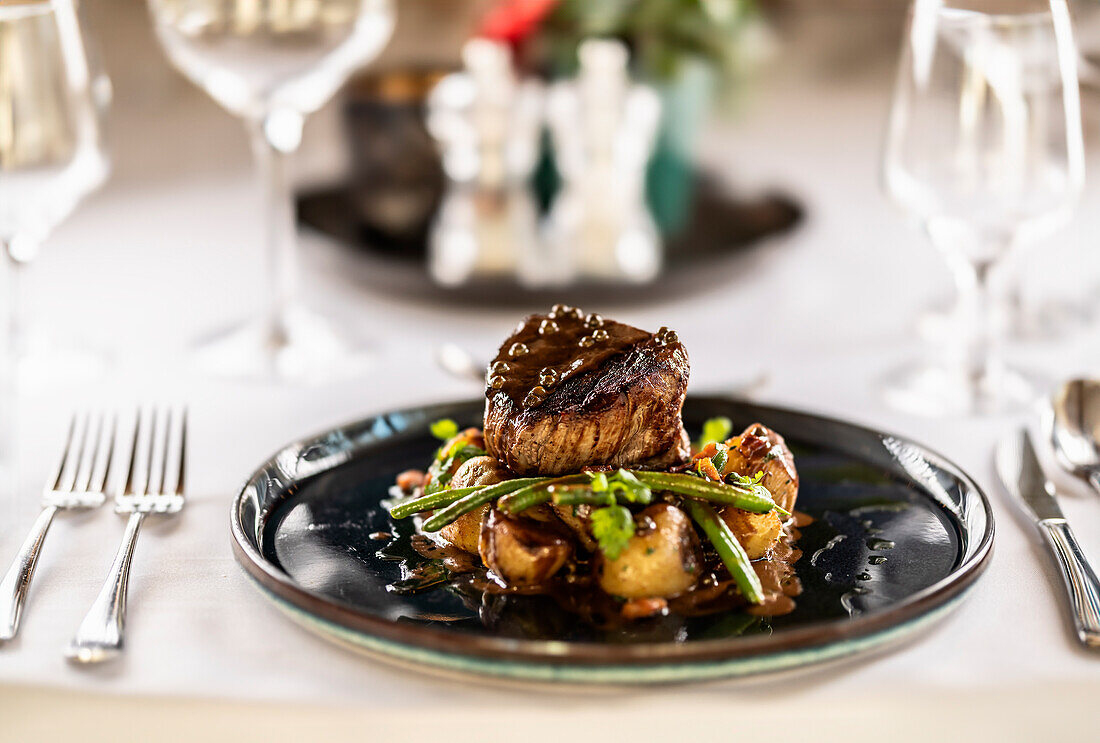 Filetsteak vom Rind, sautierte grüne Bohnen mit Speck, Ofenkartoffeln und grüne Pfeffersauce