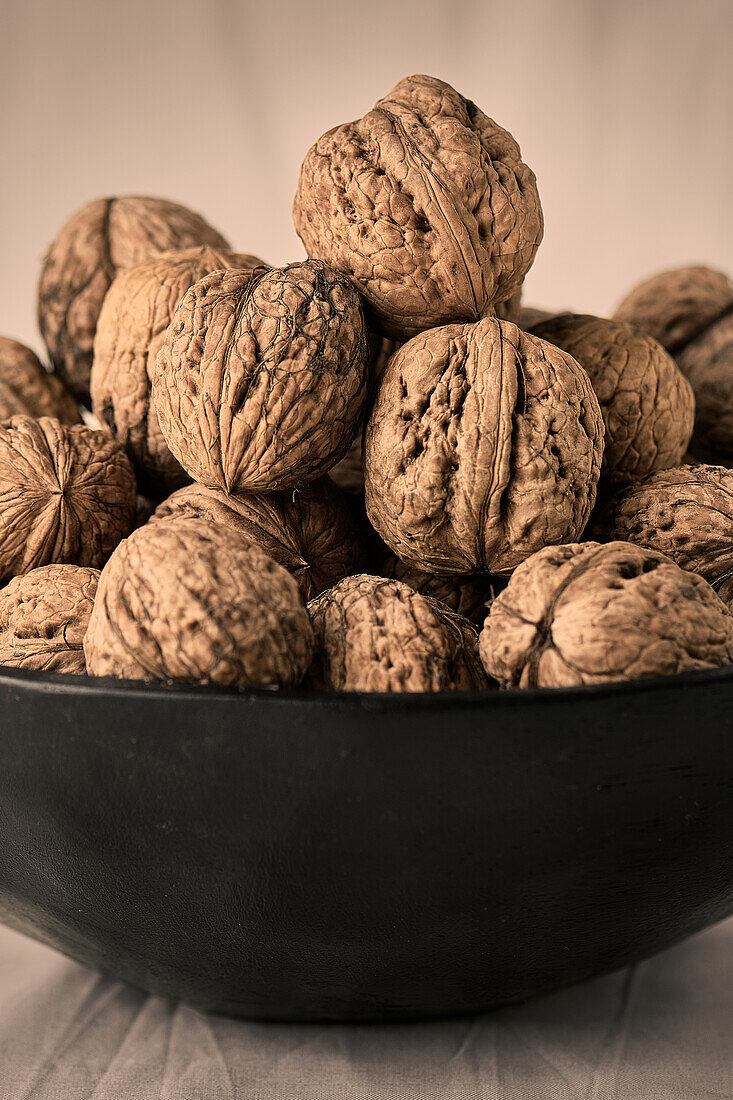 Black bowl with whole walnuts