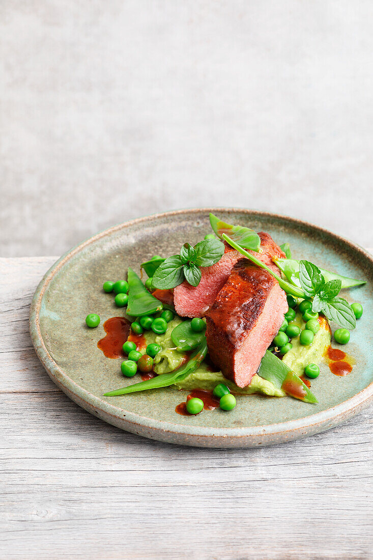 Lamb fillets with pea and mint guacamole and mangetout salad