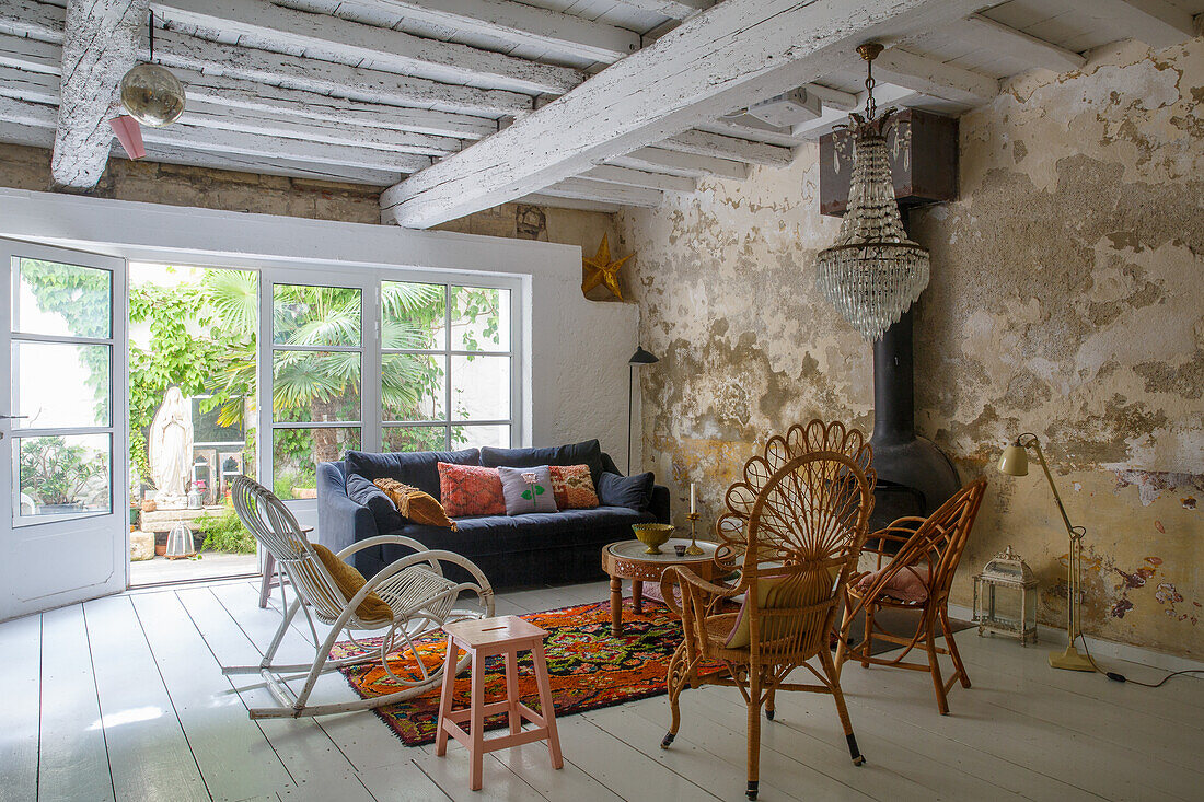 Living room with vintage furniture, carpet and chandelier, rustic walls, access to the garden