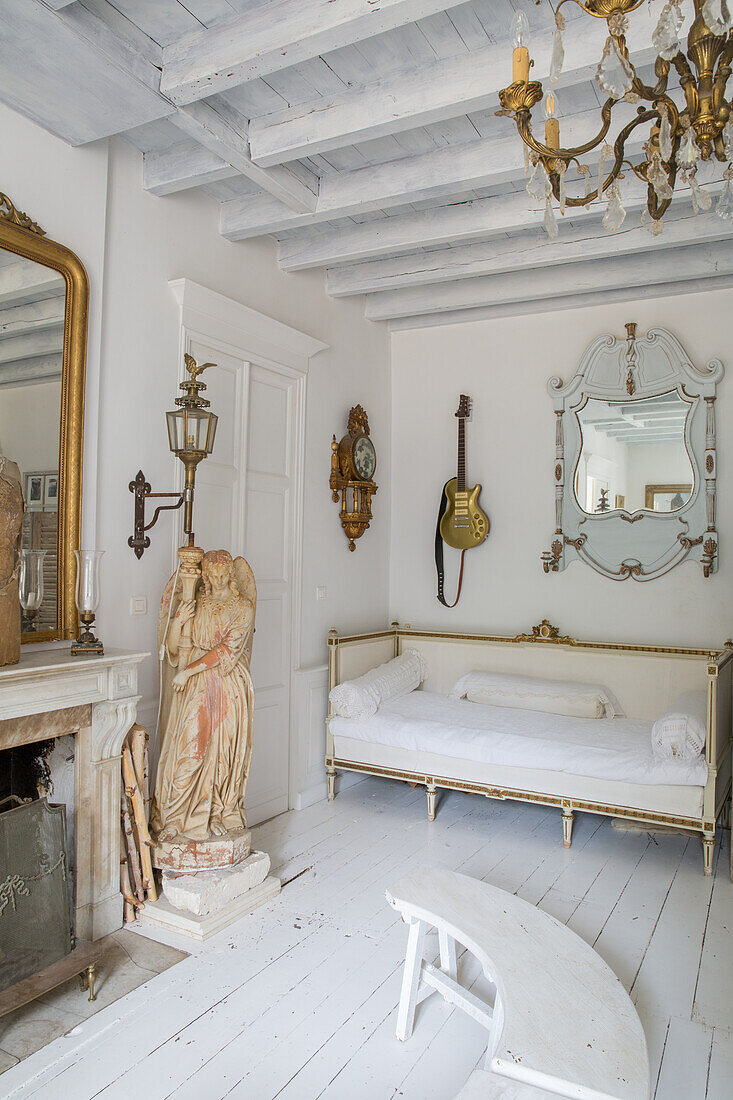 Bright, antique living room with angel sculpture and gold-decorated guitar on the wall