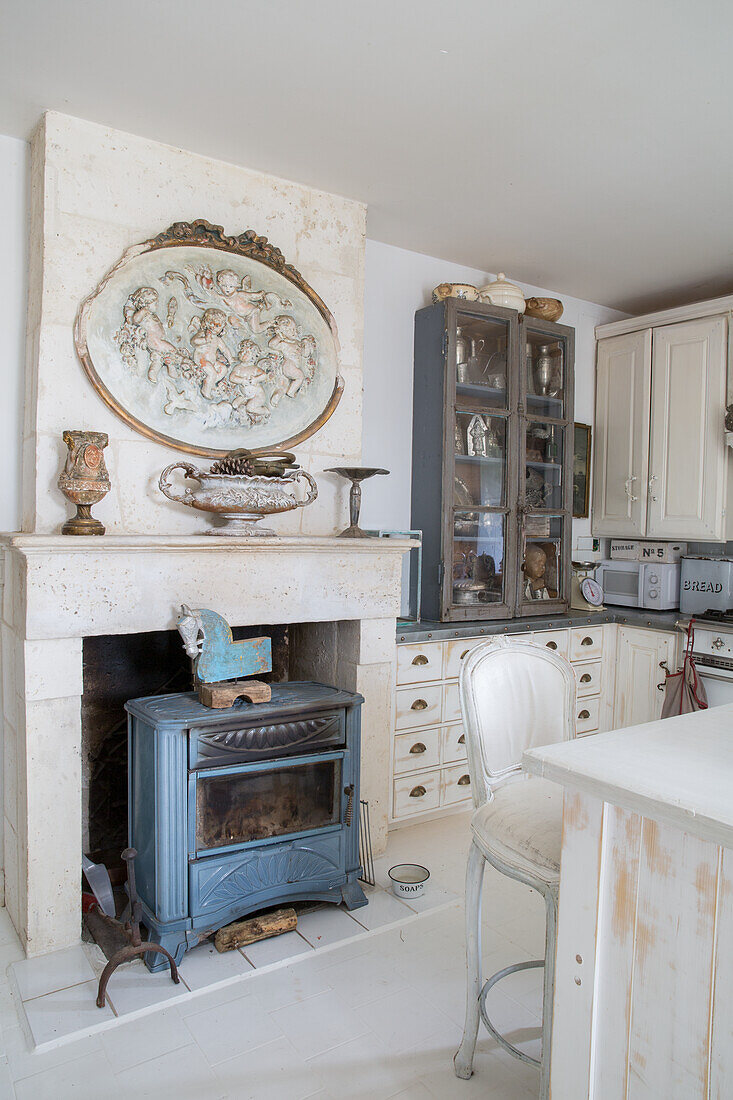 Country-style kitchen with blue wood-burning stove and antique decorations