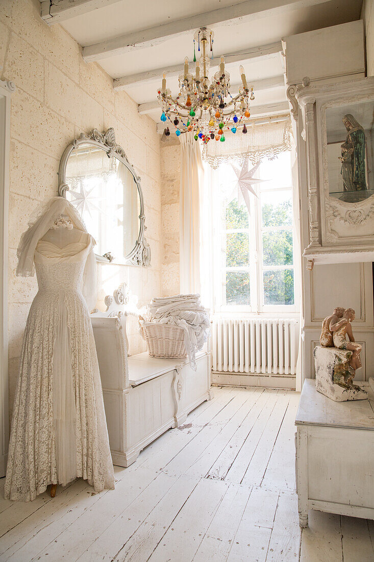 Bright dressing room with dressmaker's dummy, antique mirror and colourful chandelier