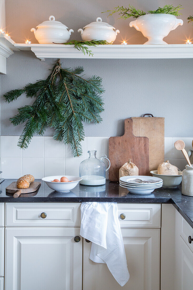 Kitchen with open shelves, fir branches and wooden chopping boards