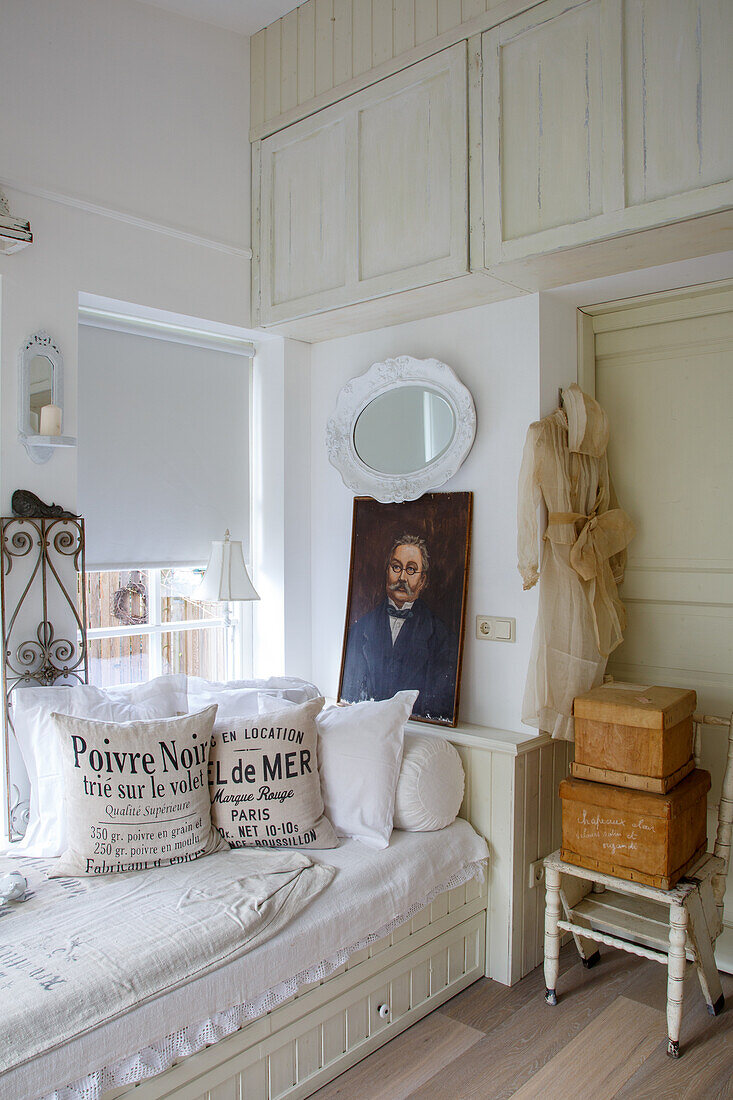 Shabby chic furnishings in a small room with a day bed and vintage decorations