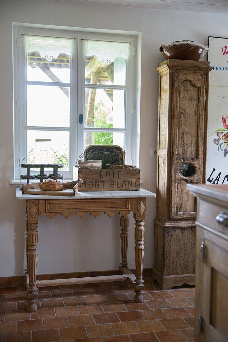 Rustic wooden table with vintage milk crate and bread in the country-style kitchen area