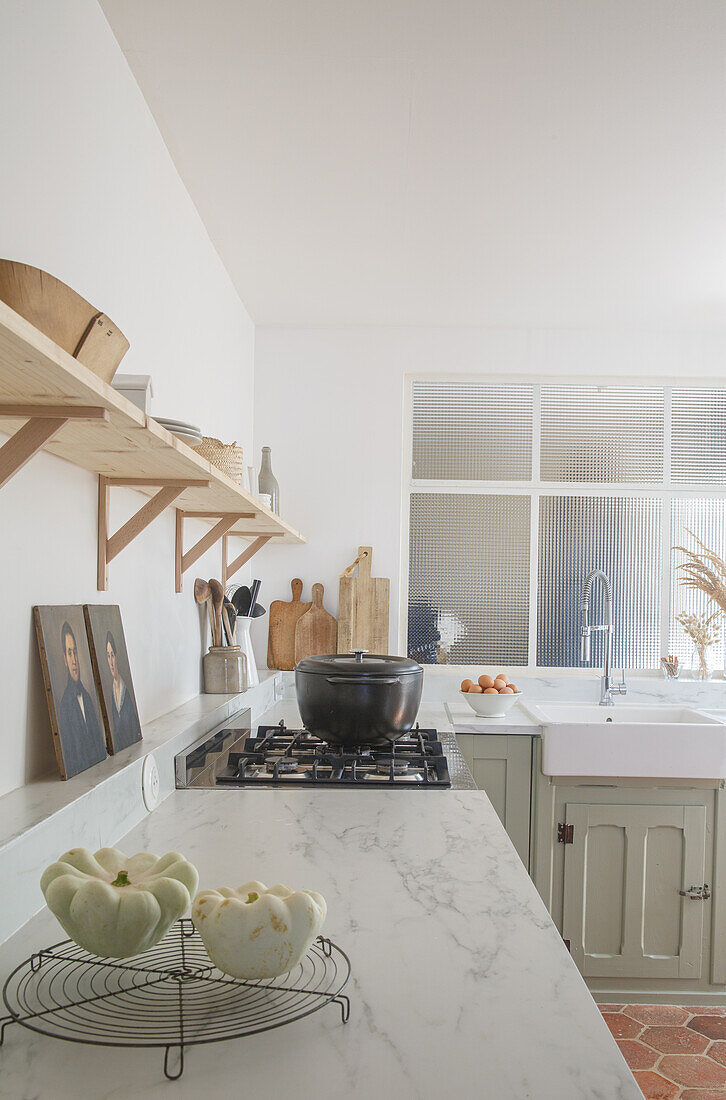 Bright kitchen with marble worktop, gas hob and shelves