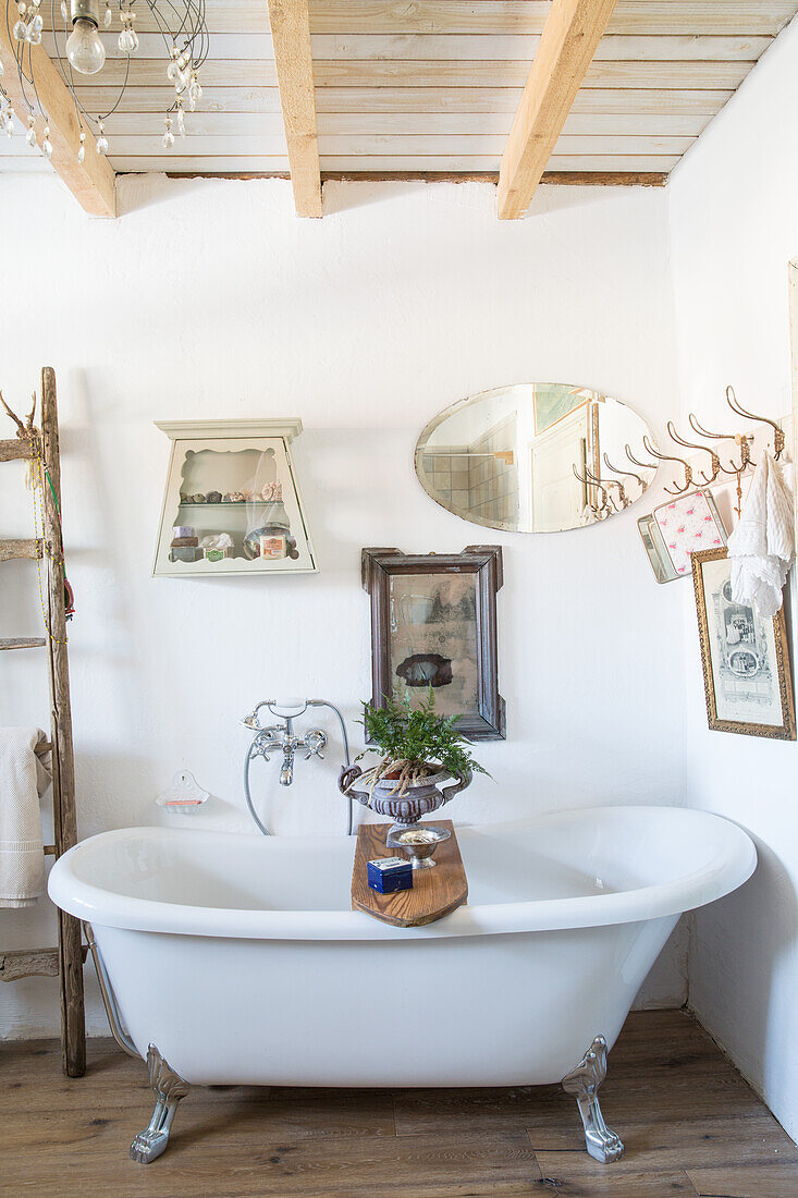 Freestanding bathtub with lion feet and wooden beam ceiling