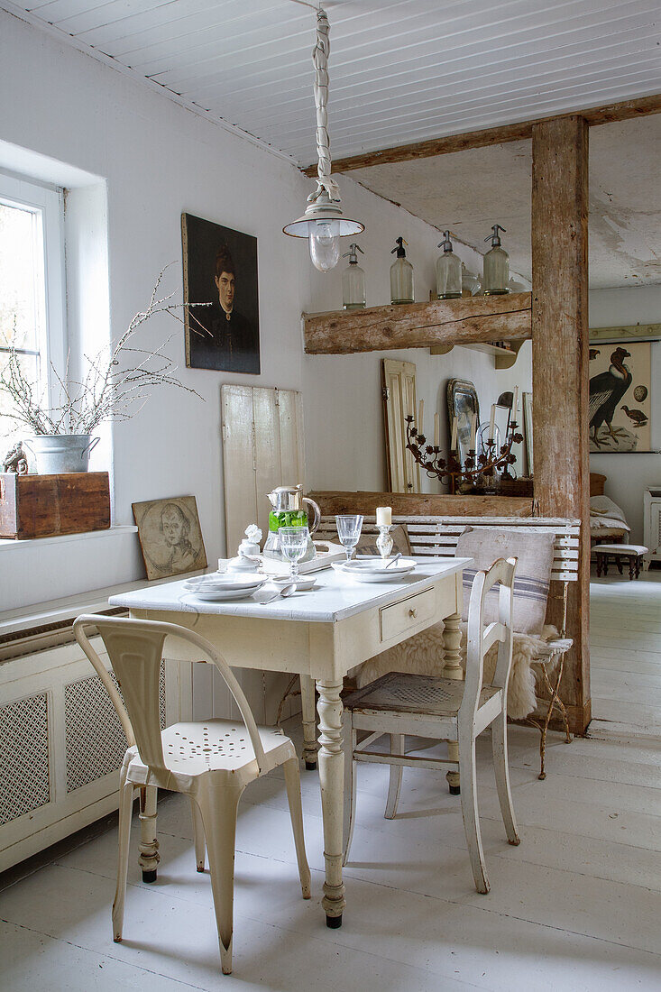 Dining area with white wooden table and metal chairs in Scandinavian country house style