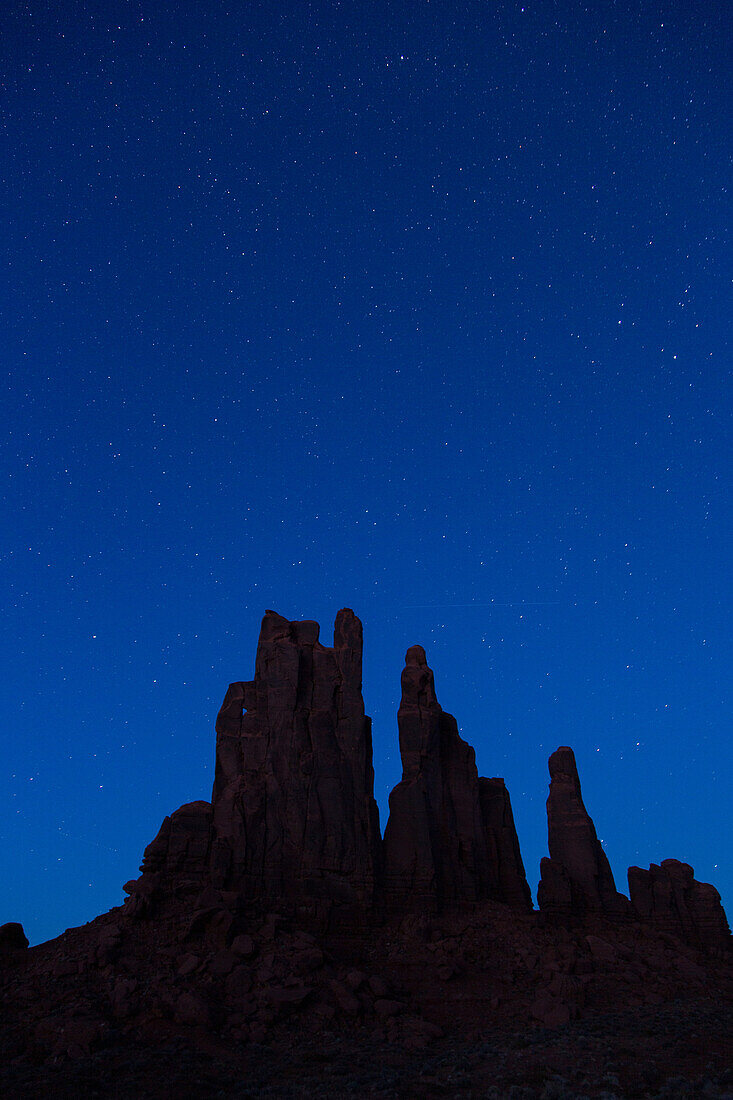 Sterne über dem mondbeschienenen Yei Bi Chei bei Nacht im Monument Valley Navajo Tribal Park in Arizona