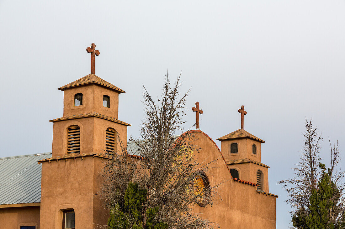 The bell towers & facade of the old mission-style Catholic parish church in San Antonio, a small town in rural New Mexico.