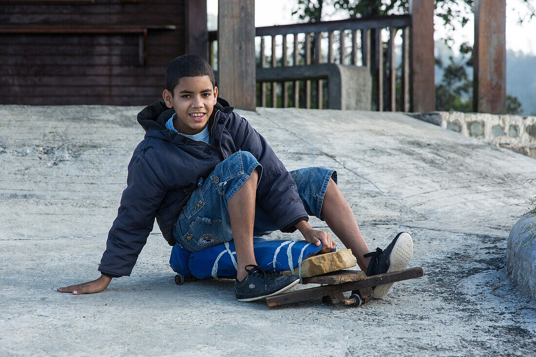 Ein dominikanischer Junge fährt auf seinem selbstgebauten Skateboard in der Nähe von Constanza in der Dominikanischen Republik