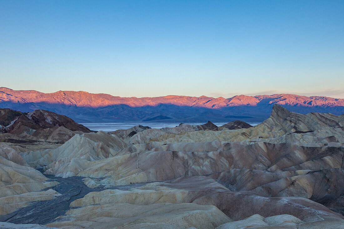 Zabriskie Point, Manly Beacon & the Panamint Mountains at sunrise in Death Valley National Park in California.