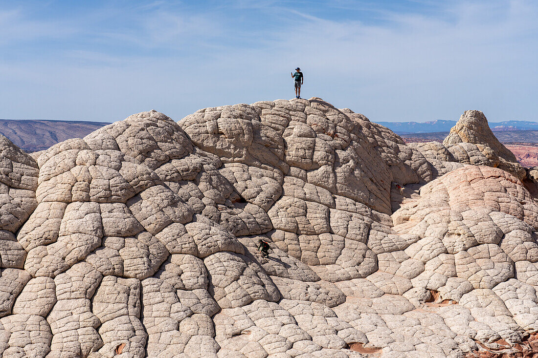 Ein Wanderer macht ein Selfie auf einer Navajo-Sandsteinformation in der White Pocket, Vermilion Cliffs National Monument, Arizona. Diese Art von weißem Navajo-Sandstein wird Pillow Rock oder Brain Rock genannt