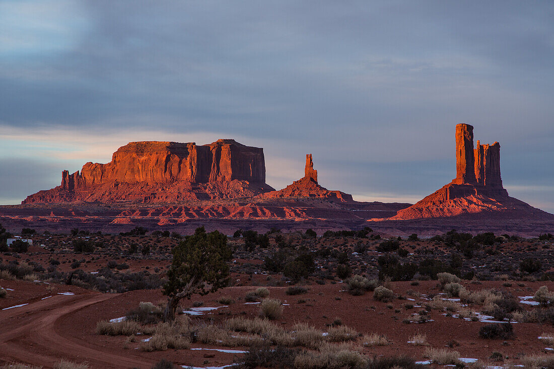Sonnenaufgang auf Sentinal Mesa, der König auf seinem Thron, Castle Butte und die Postkutsche im Monument Valley Navajo Tribal Park in Arizona. Diese Monumente werden oft als Utah-Monumente bezeichnet, weil sie direkt hinter der Grenze in Utah liegen, während der größte Teil des Parks in Arizona liegt.