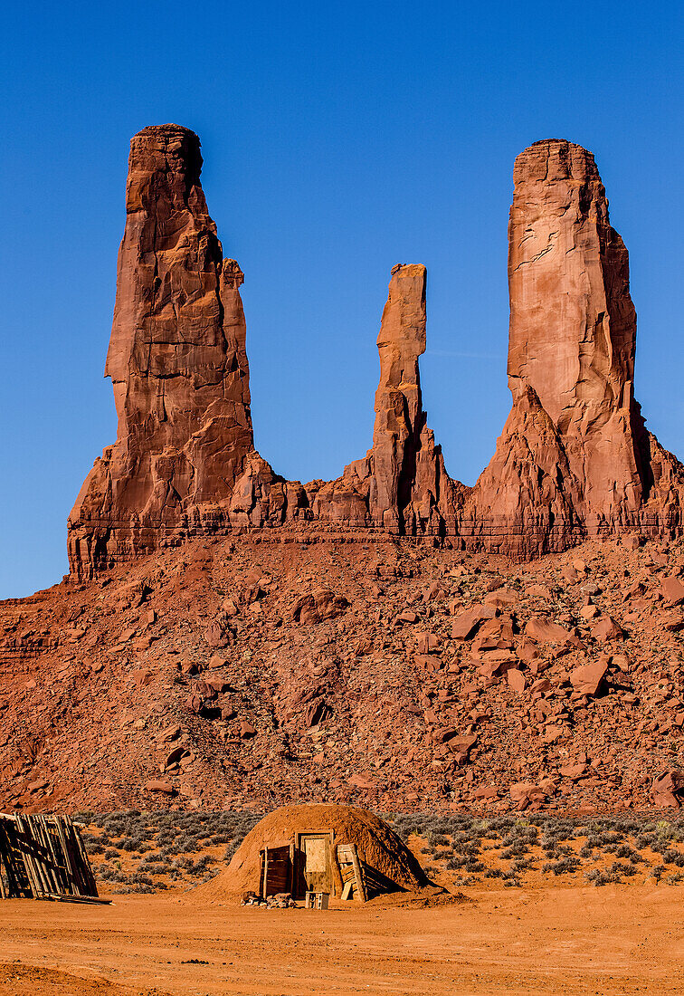 A traditional Navajo hogan in front of the Three Sisters in the Monument Valley Navajo Tribal Park in Arizona.