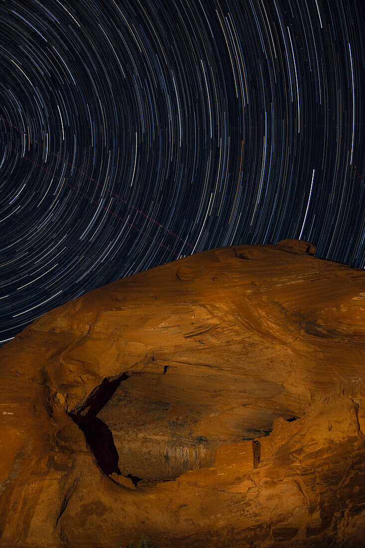 Star trails over Square House, a pre-Hispanic Ancestral Puebloan ruin in the Monument Valley Navajo Tribal Park in Arizona.