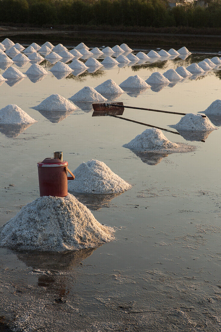 Salzstapel, ein Wasserkühler und ein Schaber in einer traditionellen Salzfarm in Samut Sakhon, Thailand