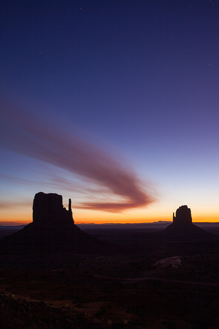 Gebogene Wolke über den Mittens vor Sonnenaufgang im Monument Valley Navajo Tribal Park in Arizona