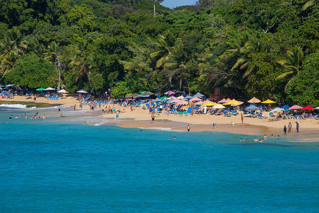 Touristen am Strand der Bucht von Sosua in der Dominikanischen Republik