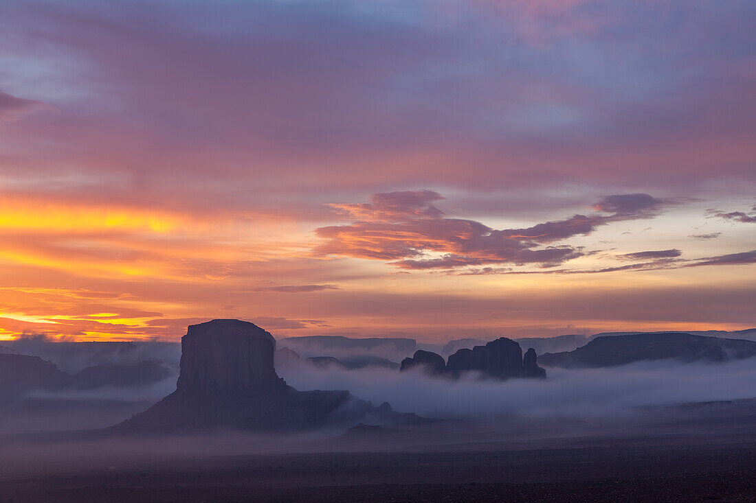 Farbenfrohe Wolken bei Sonnenaufgang über Elephant Butte und Camel Rock im Monument Valley Navajo Tribal Park in Arizona