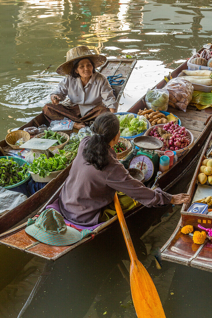 Soziale Interaktion zwischen thailändischen Verkäufern auf ihren Booten auf dem schwimmenden Markt von Damnoen Saduak in Thailand