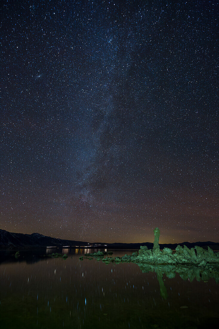 Milchstraße über Tuffsteinformationen im Mono Lake in Kalifornien mit Sternen, die sich im See spiegeln