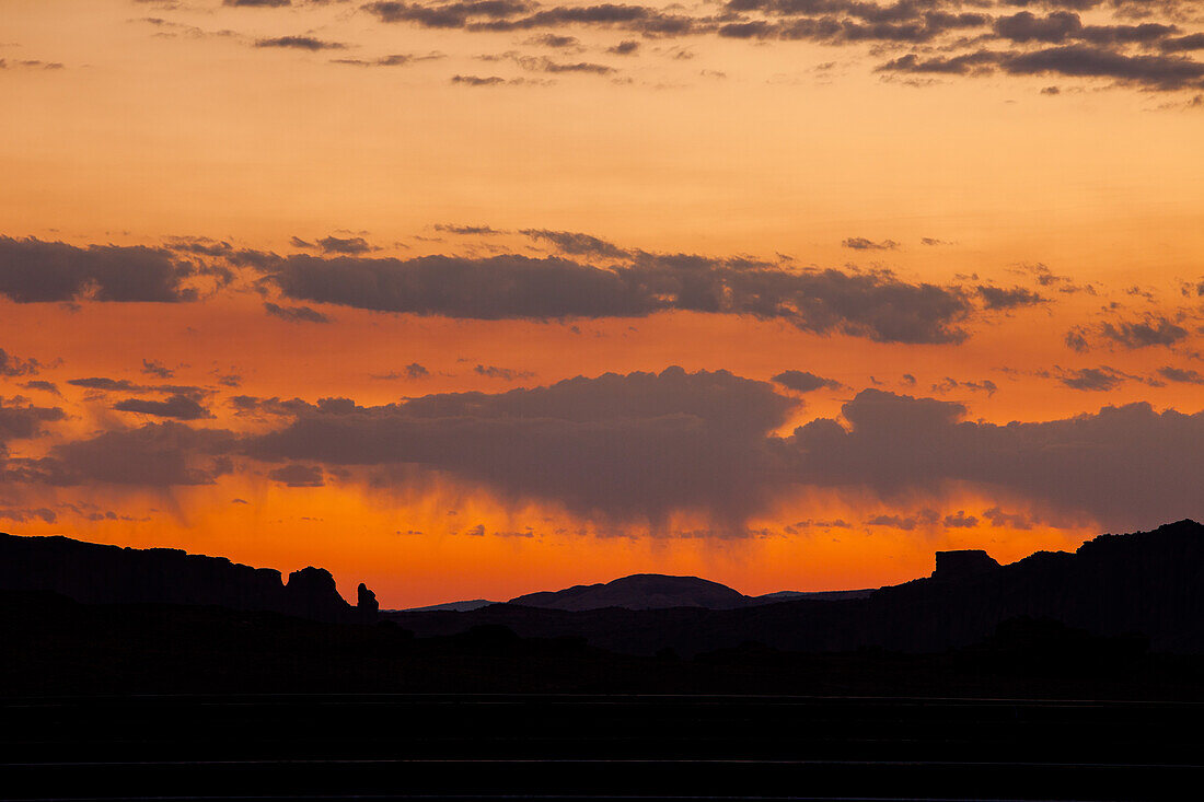 Pastel sunrise with virga or evaporating rainfall over the canyon country near Moab, Utah.