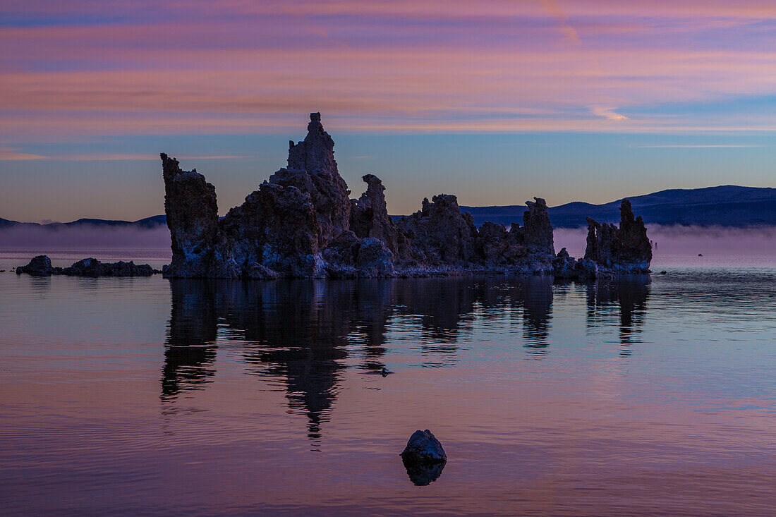 Colorful sunrise silhouettes of tufa formations in Mono Lake in California.