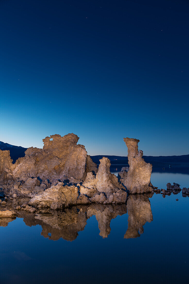 Tufa formations reflected in Mono Lake in California in evening twilight.