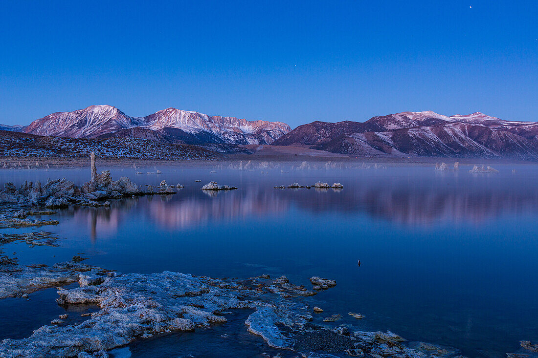 Predawn fog over the tufa formations on Mono Lake in California. The Eastern Sierra Mountains are behind.