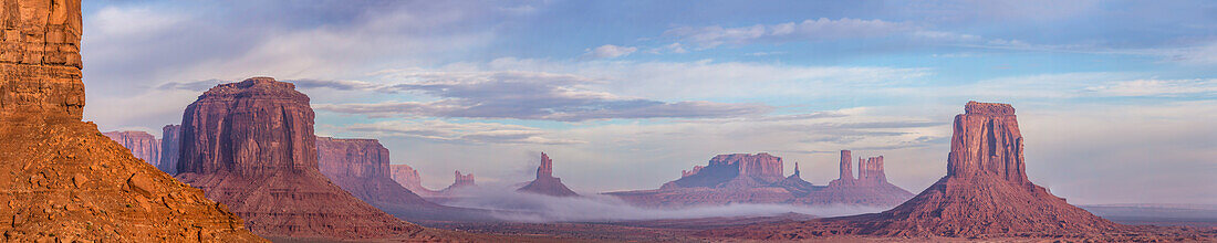 Foggy morning North Window view of the Utah monuments in the Monument Valley Navajo Tribal Park in Arizona. L-R: Elephant Butte (foreground), Merrick Butte with Sentinal Mesa behind, Setting Hen, Big Indian Chief, Brigham's Tomb, King on the Throne, Castle Butte, Bear and Rabbit, Stagecoach, East Mitten Butte.