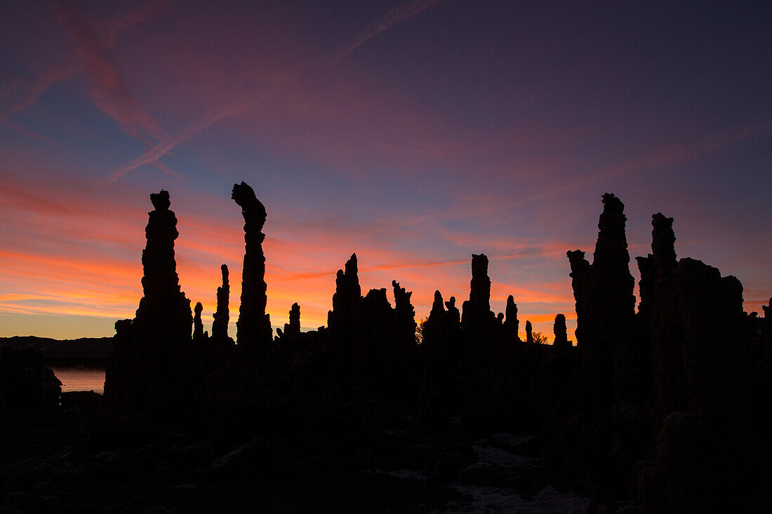 Colorful sunrise silhouettes of tufa formations in Mono Lake in California.