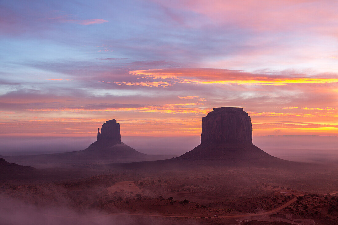 Farbenfroher Sonnenaufgang mit Bodennebel im Monument Valley Navajo Tribal Park in Arizona