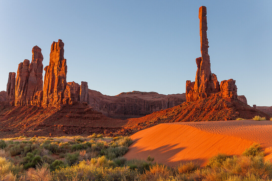 First light on the Totem Pole & Yei Bi Chei with rippled sand dunes in the Monument Valley Navajo Tribal Park in Arizona.