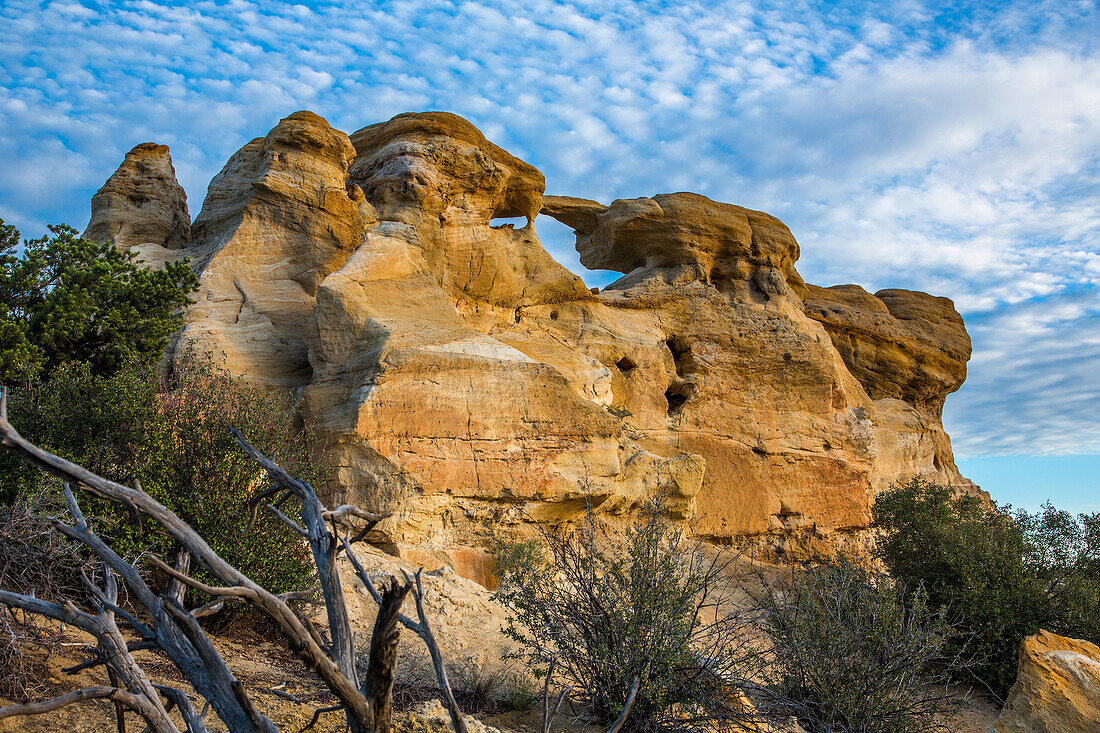 Blauer Himmel und Wolken über dem Graceful Arch in einer abgelegenen Wüste bei Aztec im Nordwesten von New Mexico