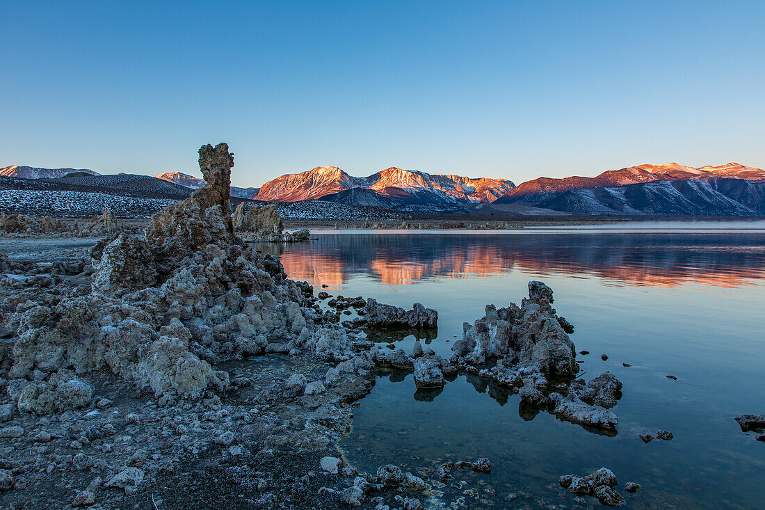 Tufa formations in Mono Lake in California at sunrise with the Eastern Sierra Mountains in the background.