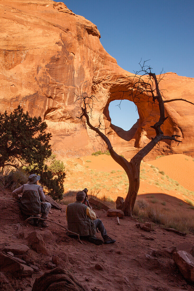 Fotografen fotografieren den Ear of the Wind Arch im Monument Navajo Valley Tribal Park, Arizona