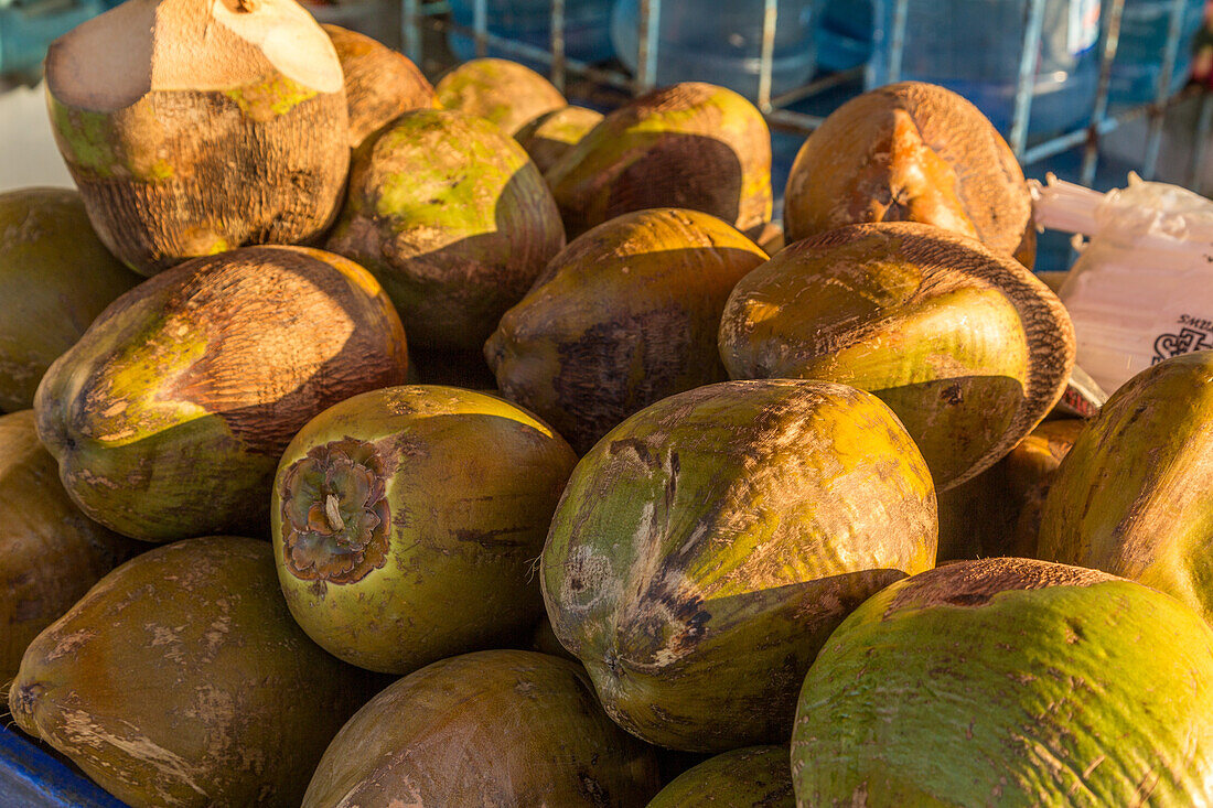 Green coconuts for sale for coconut milk at a stand on the street in Samana, Dominican Republic.