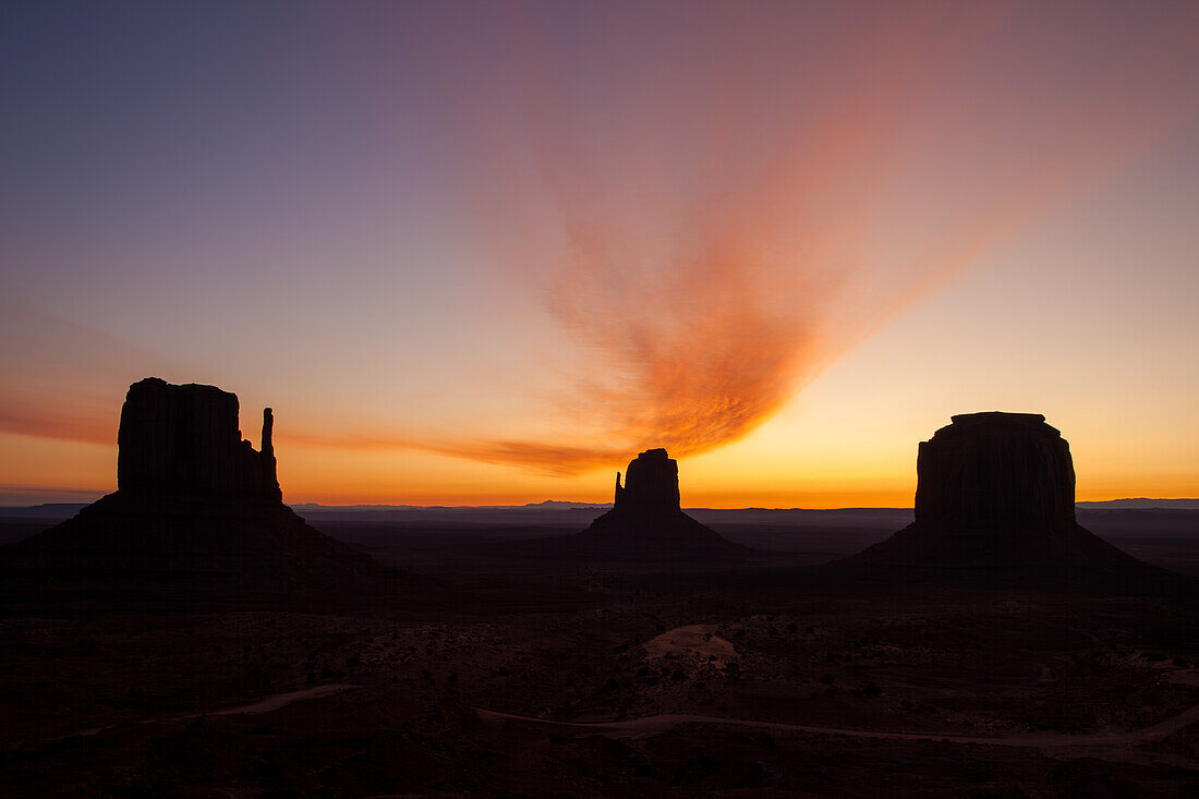 Gebogene Wolke über dem Mittens & Merrick Butte vor Sonnenaufgang im Monument Valley Navajo Tribal Park in Arizona