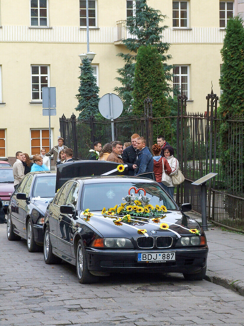 Ein für eine Hochzeit mit Blumen geschmücktes Auto vor einer Kirche in der Altstadt von Vilnius, Litauen