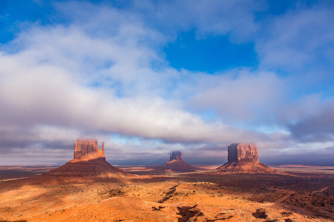 Tiefhängende Wolken über den Mittens und dem Merrick Butte im Monument Valley Navajo Tribal Park in Arizona