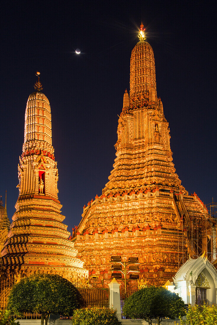 Crescent moon over Wat Arun or Temple of Dawn, a Buddhist temple in Bangkok, Thailand, with its Khmer-style prangs or spires.
